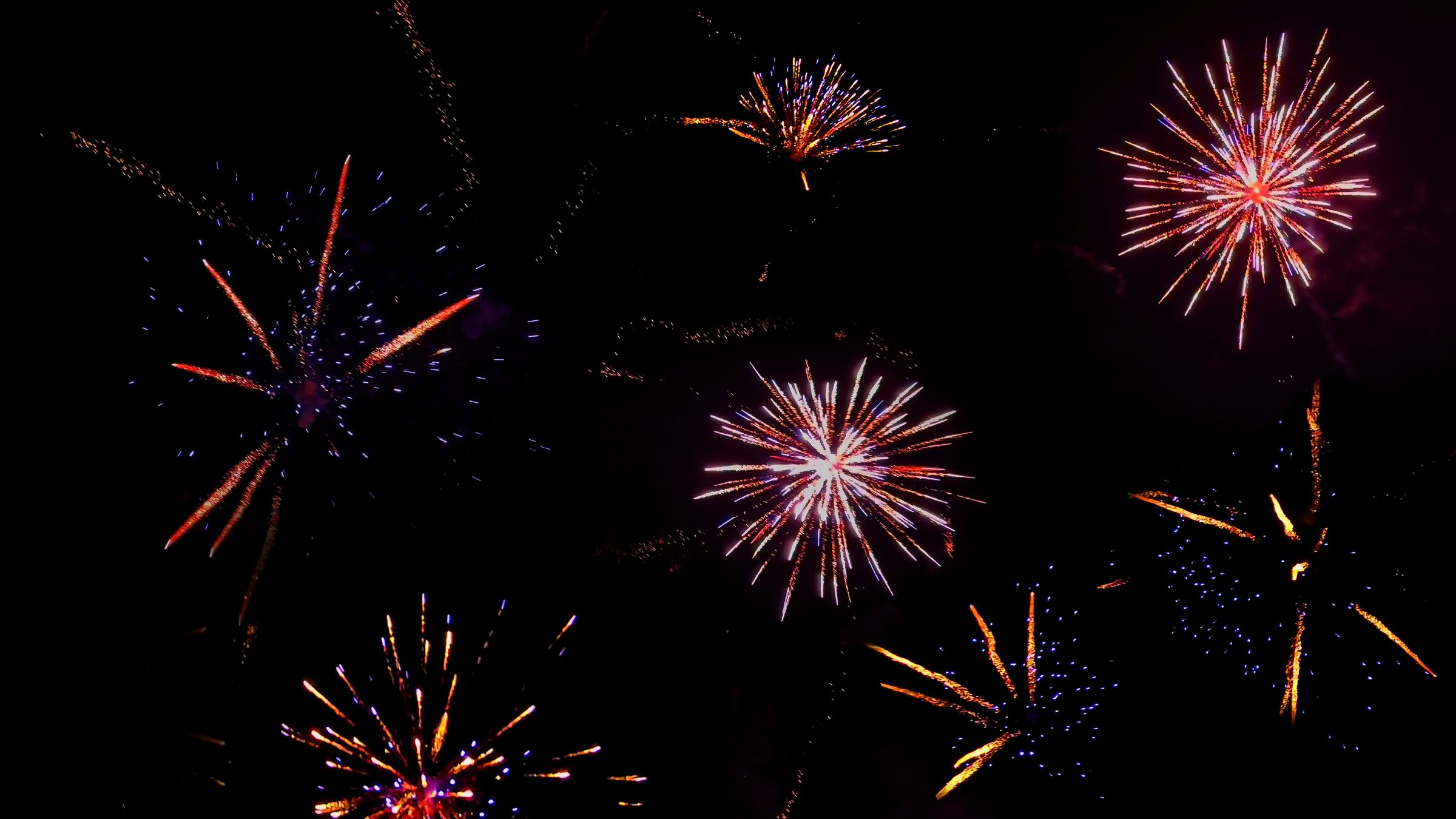 Höhenfeuerwerk über einer Hochzeitsgesellschaft — rote und weiße Effekte am Nachthimmel